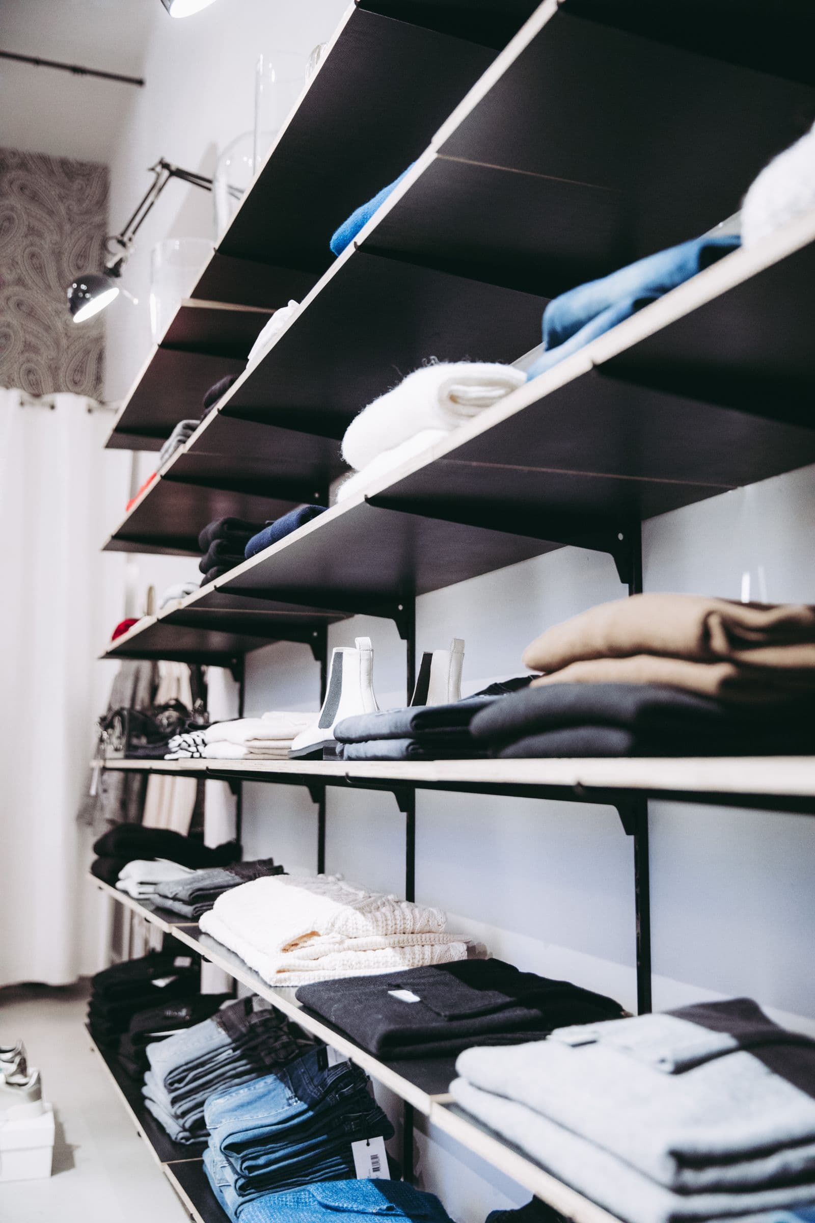 Neatly folded clothes on shelves in a clothing shop