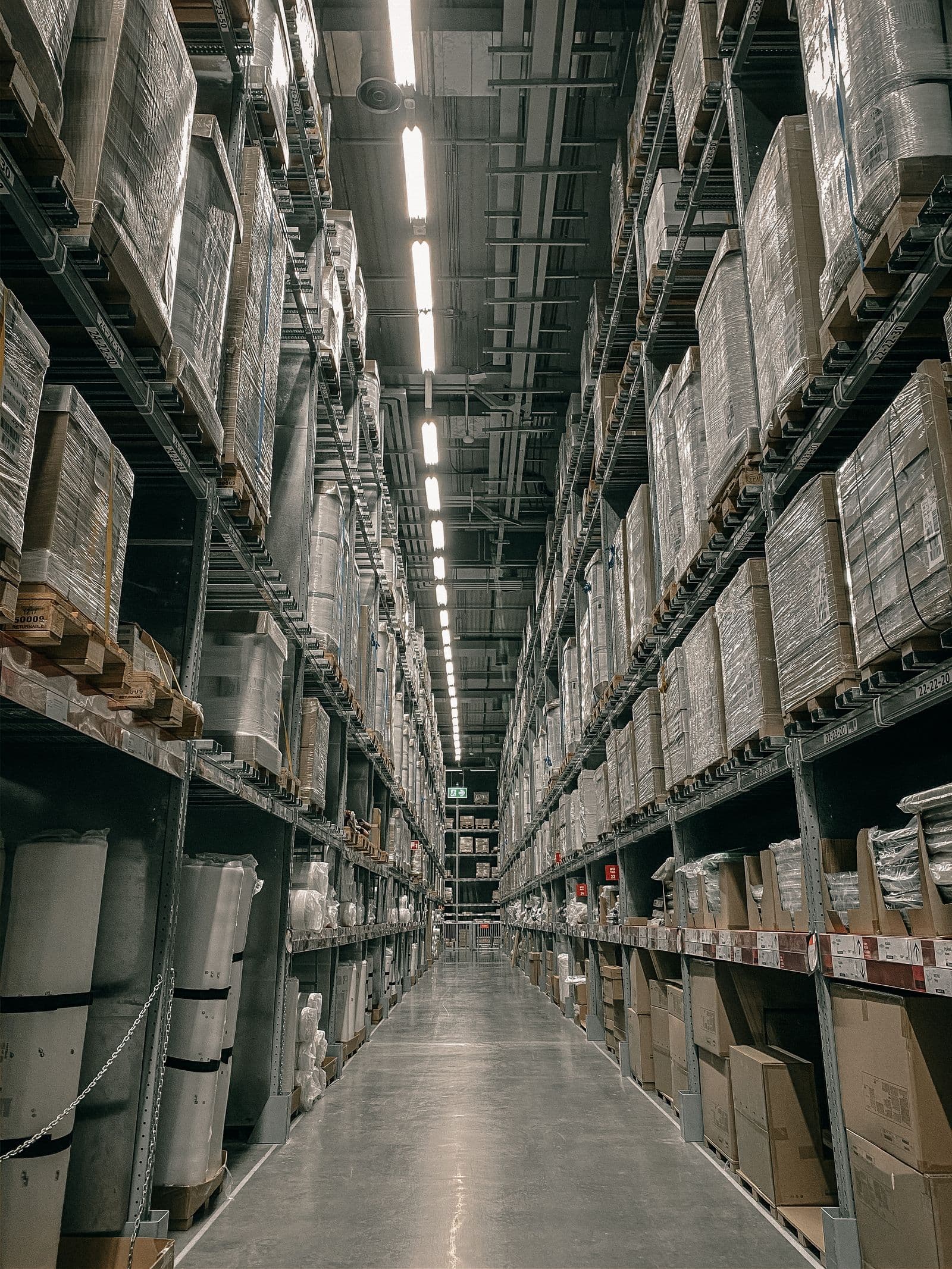 Long warehouse aisle with high shelving filled with boxes
