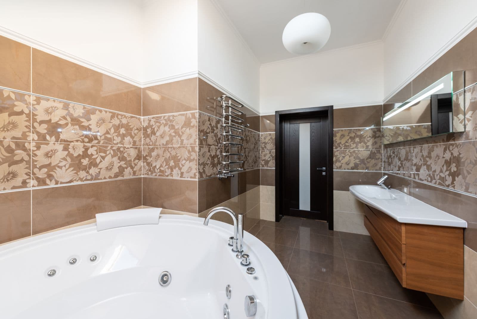 Contemporary bathroom with a white tub, sink and wooden cabinet
