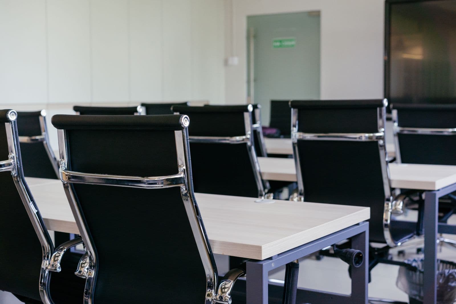 Modern meeting room with black chairs and white desks