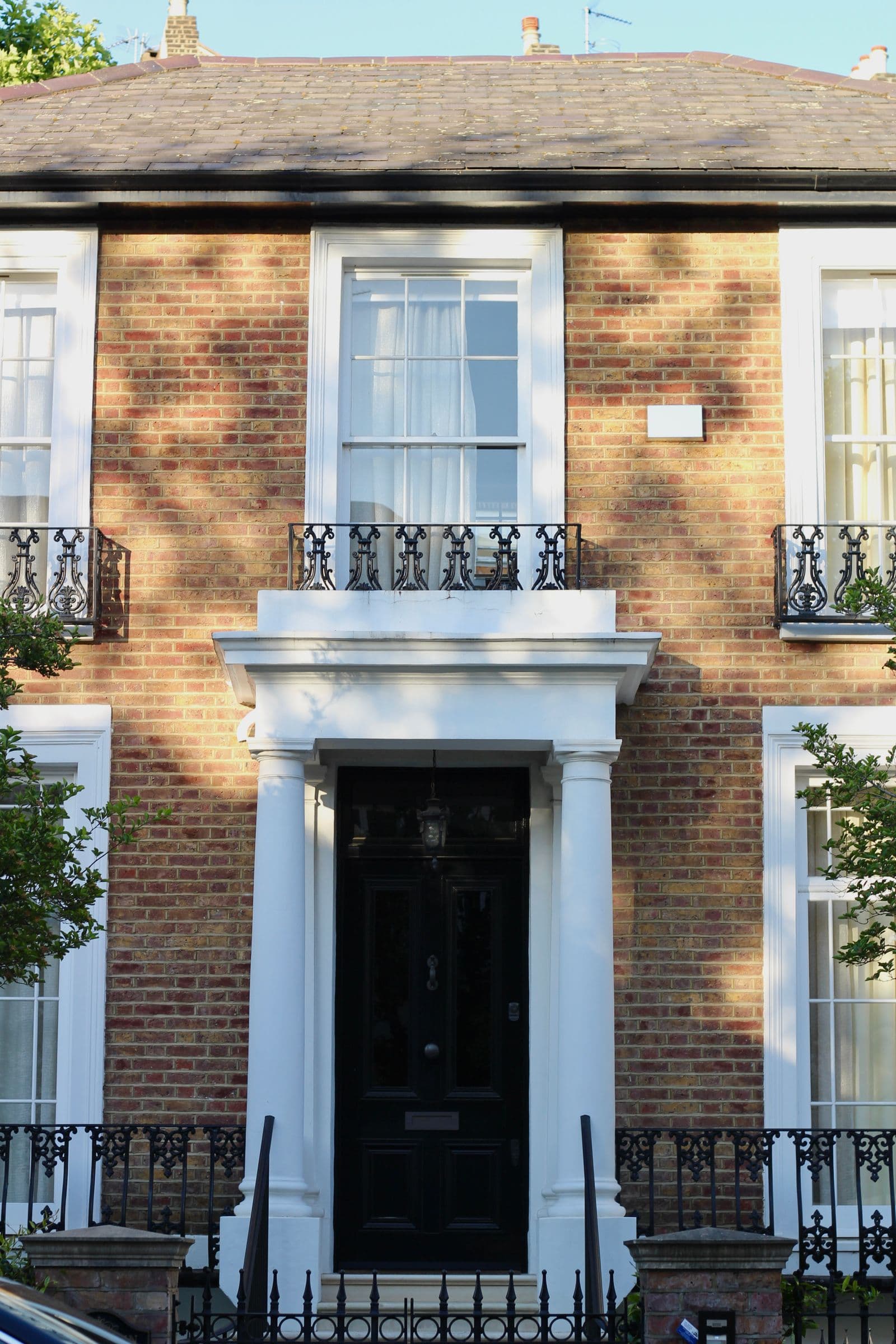 Elegant townhouse facade with white windows and ironwork
